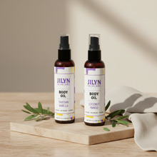 Load image into Gallery viewer, Two Jilyn Skincare Body Oil 8oz bottles styled with linen and botanicals on warm stone surface