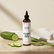 Load image into Gallery viewer, Jilyn Skincare Cucumber Aloe Toner 8oz bottle styled with fresh cucumber slices and aloe on warm stone surface
