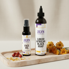 Load image into Gallery viewer, Jilyn Skincare Soap and Oil Duo — Liquid African Black Soap and Face Oil bottles styled on a marble tray with botanicals
